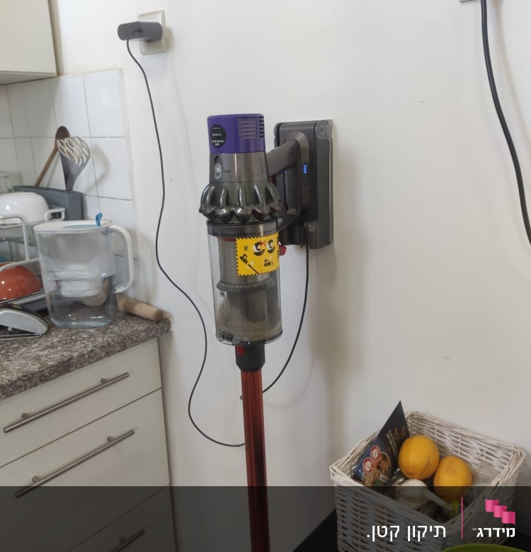 שואב אבק אלחוטי תלוי על הקיר בטעינה